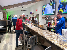 Bullseye Ink Room customer entertainment space with large-screen televisions and bar seating